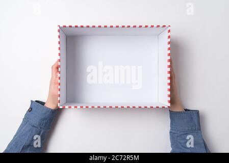Ouvrez la boîte cadeau vide dans les mains des enfants sur fond blanc. Vue de dessus Banque D'Images