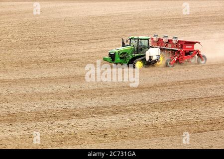 Un agriculteur et un tracteur dans le champ plantant des pommes de terre dans les champs fertiles de l'Idaho. Banque D'Images