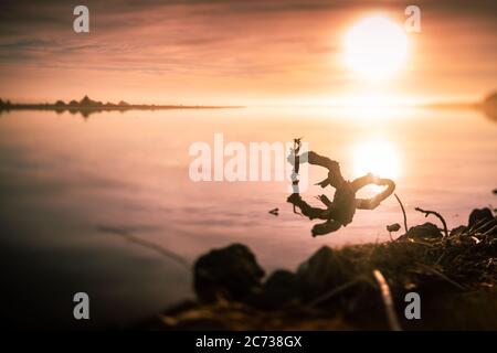 Photo rêveuse du soleil sur la rivière avec des billes en premier plan. Banque D'Images