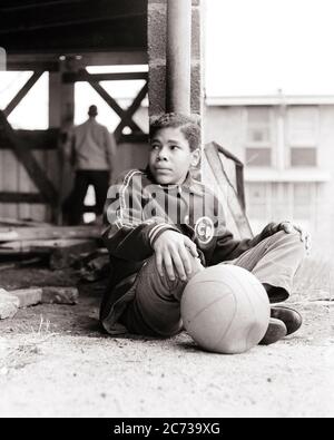 LES ANNÉES 1960, ADOLESCENT AMÉRICAIN S'ENNUYANT ASSIS DANS UN TERRAIN DE JEU DE VILLE DÉLABRÉ AVEC SON BASKET DÉLABRÉ - N1944 HAR001 HARS FITNESS JUVÉNILE COLÈRE FACIALE PEUR SANTÉ SÉCURITÉ ATHLÈTE STYLE DE VIE MAUVAISE SANTÉ VIE VIE MAISON COPIE ESPACE PERSONNES PLEINE LONGUEUR INSPIRATION HOMMES RISQUE ADOLESCENT GARÇON CONFIANCE ATHLÉTIQUE EXPRESSIONS B&W TRISTESSE TENTATION ACTIVITÉ RÊVES PHYSIQUE SA FORCE AFRO-AMÉRICAINS EXTÉRIEUR AFRO-AMÉRICAIN PUISSANT LOISIRS NOIR ORIGINE ETHNIQUE DIRECTION FIERTÉ SENTIMENT CONCEPTUEL ÉCHAPPER FLEXIBILITÉ MUSCLES ADOLESCENTS DÉFAVORISÉS DÉCOURAGÉS DÉÇUS Banque D'Images