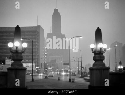 LES LAMPADAIRES OBÉLISQUES DES ANNÉES 1960 SUR WACKER CONDUISENT LE TRAFIC DU CENTRE-VILLE PENDANT LA NUIT BRUMEUSE LE LONG DE CHICAGO RIVER CHICAGO ILLINOIS USA - R20452 HAR001 HARS BRUMISH VÉHICULES EDIFICE ILLINOIS NOIR ET BLANC HAR001 IL LAMPADAIRES MIDWEST OBÉLISQUE ANCIEN MODE Banque D'Images