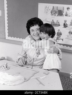 ANNÉES 1970, RIRE PETITE FILLE EMBRASSANT SOURIRE MATERNELLE OU MATERNELLE ENSEIGNANT ASSIS EN CLASSE TOUS DEUX REGARDANT LA CAMÉRA - S21726 HAR001 HARS OCCUPÉ FUTUR NOSTALGIE EMBRASSANT LA VIEILLE MODE 1 JEUNE COMMUNICATION FACIALE RIRE ÉQUILIBRE EMBRASSER PLAISIR STYLE DE VIE CÉLÉBRATION FEMMES COPIE ESPACE DEMI-LONGUEUR HUG DAMES PERSONNES INSPIRATION SPIRITUALITÉ BIENVEILLANTE CONFIANCE EMBRASSANT LES EXPRESSIONS MOYEN-ÂGE B&W CONTACT VISUEL SUCCÈS BONHEUR MATERNELLE MATERNELLE MOYENNE ÂGE FEMME BIEN-ÊTRE JOYEUSE AVENTURE LES DEUX FORCE EXCITATION PUISSANTE FIERTÉ DANS LES PROFESSIONS D'AUTORITÉ CONNEXION Banque D'Images