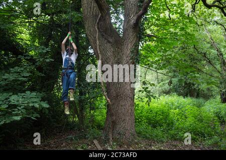 Denham, Royaume-Uni. 13 juillet 2020. Un activiste de la rébellion HS2 monte jusqu'à une maison d'arbres au camp de protection Denham. Le camp a été créé par les activistes afin d'essayer d'empêcher la destruction des bois pour la liaison ferroviaire à grande vitesse HS2 de 106 milliards de livres sterling, qui restera un contributeur net aux émissions de CO2 pendant sa durée de vie prévue de 120 ans. Crédit : Mark Kerrison/Alamy Live News Banque D'Images