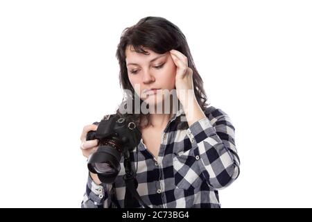 Jeune femme photographe professionnel indépendant, étudiante en art ou photojournaliste sur fond blanc tenant un appareil photo. Elle se sent malade ou pas Banque D'Images