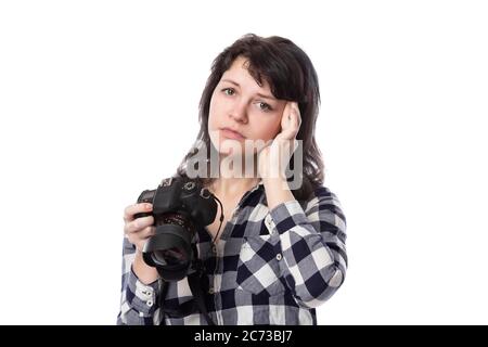 Jeune femme photographe professionnel indépendant, étudiante en art ou photojournaliste sur fond blanc tenant un appareil photo. Elle se sent malade ou pas Banque D'Images