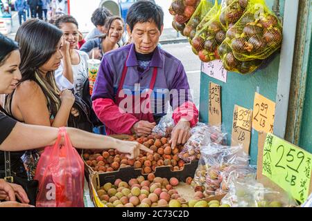 San Francisco California, Chinatown Grant Street kanji shopping shoppers homme asiatique, femme hispanique femme pointant produit fournisseur stand stand stand marché mar Banque D'Images