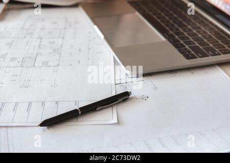Gros plan des plans avec croquis de projets, ordinateur portable et stylo. Banque D'Images