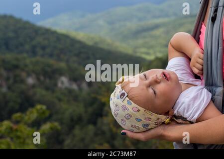 randonnée avec bébé endormi dans le sac à dos collines vertes derrière Banque D'Images