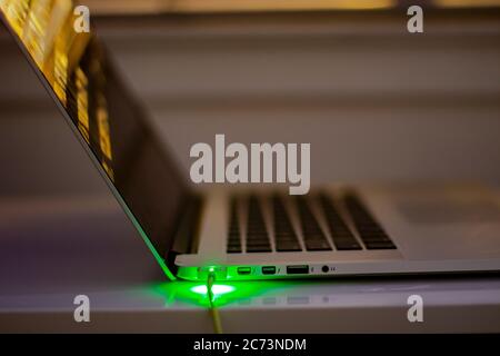 Calgary, Alberta. Canada. 14 juillet 2020. L'ordinateur MacBook se charge pendant la nuit, vue latérale du port d'alimentation MagSafe 2 Banque D'Images