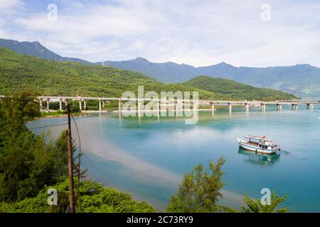 Magnifique paysage de la baie de Lang Co dans le matin ensoleillé. Bateau sur la plage et chemin de fer au-dessus. Lang Co Bay - Vietnam Banque D'Images