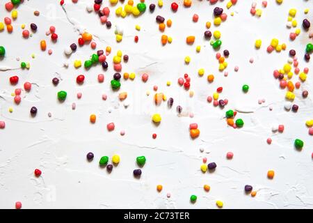 Bonbons multicolores parsemés sur fond blanc. Banque D'Images