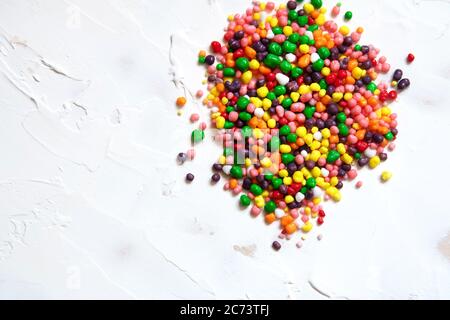 Bonbons multicolores parsemés sur fond blanc. Banque D'Images