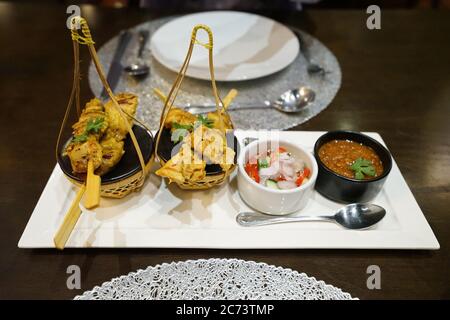 Brochettes de poulet servies avec une sauce épaisse à l'arachide et une prune AR de lard (concombre et oignon dans du vinaigre de relish) Banque D'Images