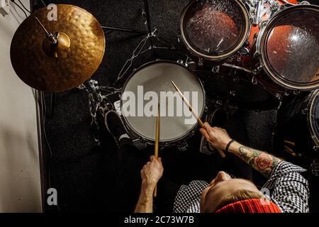 vue de dessus sur un beau gars talentueux jouant sur la batterie, jeune homme caucasien passionné de musique, se préparant pour le concert, rock and roll performance. musique, instrume Banque D'Images