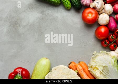 Divers légumes crus sur fond gris avec un espace de copie en cercle. Courgettes, concombre, piment, champignons, tomate, chou-fleur, le Banque D'Images