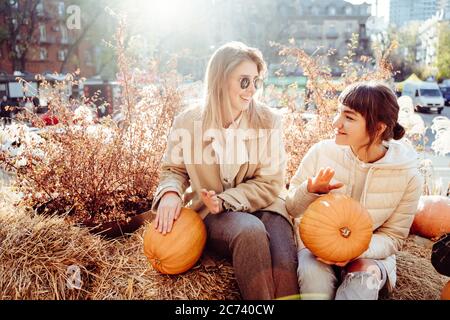 Les filles tient les citrouilles dans les mains sur le fond de la rue. Banque D'Images