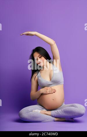 Soins à l'enfant à naître. Bonne femme enceinte pratiquant des cours de yoga prénatal au troisième trimestre préparant son corps à l'accouchement naturel Banque D'Images