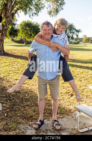 Couple âgé de plus en plus amoureux s'embrassant et s'amuser ensemble dans le parc par beau temps. Amour, espoir, personnes actives et mode de vie sain C Banque D'Images