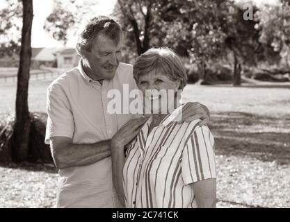 Portrait d'un couple de personnes âgées de race blanche dans les années 70, qui s'embrasse en montrant l'amour et l'affection dans le parc. Vieillir ensemble, amour, style de vie de retraite et de retour Banque D'Images
