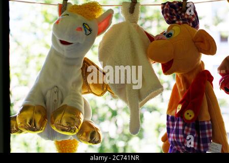 Les jouets pour enfants sont séchés sur des épingles à linge. Les jouets mous sont suspendus sur une corde à linge, les jouets sont fixés avec des épingles à linge. Banque D'Images