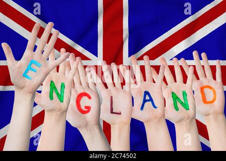 Inscription de l'Angleterre sur les mains des enfants, sur fond de drapeau agitant de la Grande-Bretagne. Banque D'Images