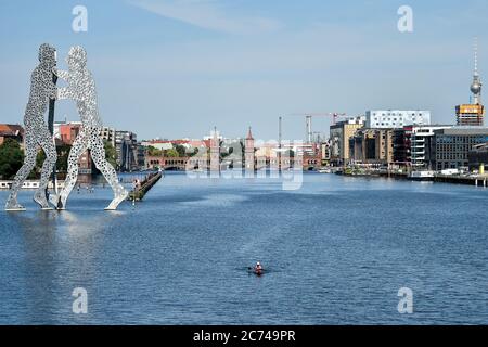 Berlin, Allemagne. 14 juillet 2020. Un canoéiste se promène à côté de la sculpture d'environ 30 mètres de haut « Molecule Man » sur la Spree. Credit: Sven Braun/dpa/Alay Live News Banque D'Images