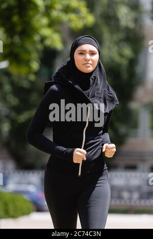 jeune fille arabe dans hijab et sportswear jogging à l'extérieur Banque D'Images