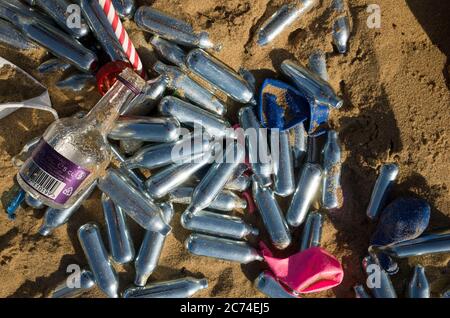 Grande quantité de bidons d'oxyde nitreux rejetés dans le sable entre autres litières sur la plage de Margate, Kent, après la vague de chaleur pendant la COVID-19. Banque D'Images