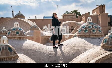 Kashan, Iran - Mai 2019: Femme iranienne sur le toit en dôme de brique de la maison de bain Sultan Amir Ahmad Qasemi Banque D'Images