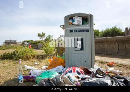 Les poubelles de plage ont laissé déborder et entouré de litière, après la vague de chaleur pendant la COVID-19 à Whitstable, dans le Kent. Banque D'Images