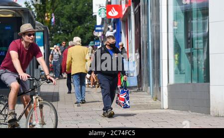 Brighton UK 14 juillet 2020 - les amateurs de shopping dans les rues de Brighton portent des masques aujourd'hui . A partir du vendredi 24 juillet, il sera obligatoire pour les personnes de porter des masques ou des couvertures à l'intérieur des magasins en Angleterre et ils pourraient recevoir des amendes allant jusqu'à £100 pour non-conformité . Les nouvelles règles sont introduites pour aider dans la lutte contre la pandémie de coronavirus COVID-19 : crédit Simon Dack / Alay Live News Banque D'Images