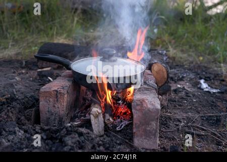 Saucisses de viande hachées grillées, dans une poêle près du feu Banque D'Images