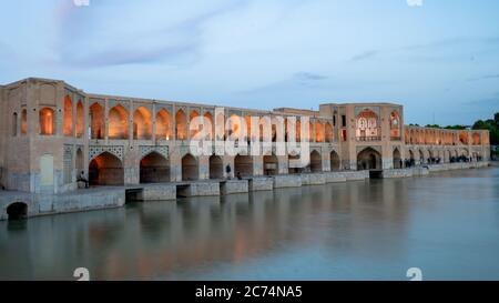 Ispahan, Iran - Mai 2019: Pont de Khaju au-dessus de la rivière Zayandeh au crépuscule avec des lumières Banque D'Images