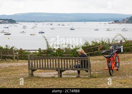 Sandbanks, Poole, Dorset Royaume-Uni. 14 juillet 2020. Evening Hill à Sandbanks est un endroit populaire pour les gens pour s'arrêter, admirer et photographier les vues spectaculaires et les couchers de soleil surplombant Poole Harbor. C'est la route principale vers/depuis Sandbanks qui est congestionnée en temps de pointe. 43 les places de stationnement dans les rues sont retirées et remplacées par une voie de cycle d'essai avec 240 mètres de bornes souples pour encourager les gens à faire du vélo pour soutenir les ambitions climatiques et écologiques du Conseil et dans le cadre des mesures du système de fonds de voyage actif d'urgence du ministère des Transports. Crédit : Carolyn Jenkins/Alay Live News Banque D'Images