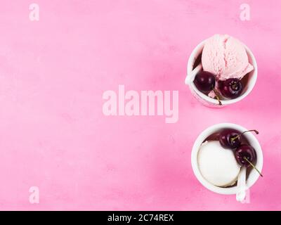 Deux tasses de crème glacée avec cerises sur rose Banque D'Images