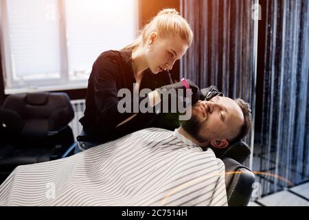 Barbier se raser un homme dans un salon de coiffure, gros plan Banque D'Images