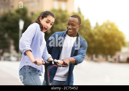 Guy et fille ayant porté sur le scooter électrique de coup Banque D'Images