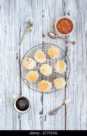 Scones anglais traditionnel frais de canneberge ou de thé de cerise sur un ancien baker sur fond rustique avec beurre de pêche et crème fraîche épaisse. T Banque D'Images