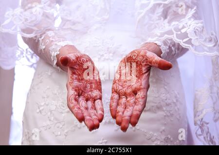 Les modèles de mariage de mariage Mehndi utilisent le colorant Henna sur les mains d'une mariée. Banque D'Images