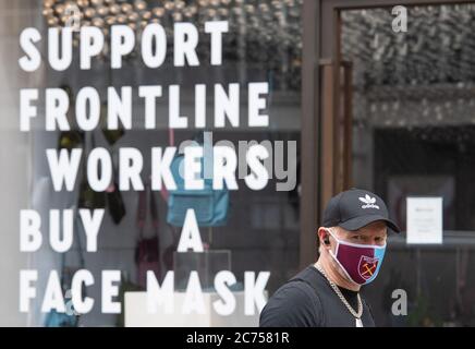 Un acheteur portant un masque sur Regent Street, Londres, avant l'annonce qu'il sera bientôt obligatoire de porter un masque dans les magasins d'Angleterre. Banque D'Images