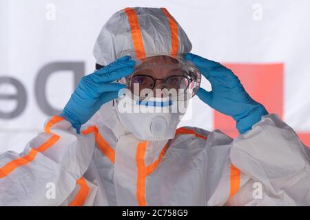 Dippoldiswalde, Allemagne. 14 juillet 2020. Une employée de la Croix-Rouge allemande (DRK) en vêtements de protection prépare sa mission dans un poste mobile d'échantillonnage Covid-19 à l'occasion d'un rendez-vous à la presse. La station est destinée à fournir un test indépendant de l'emplacement pour les cas présumés de Covid-19 dans l'État libre. Credit: Sebastian Kahnert/dpa-Zentralbild/dpa/Alay Live News Banque D'Images