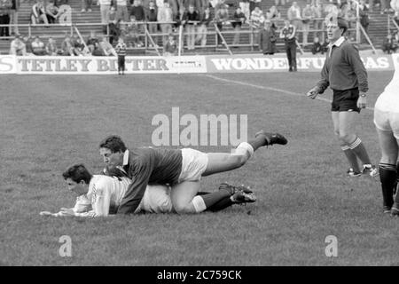 La moitié de la mêlée de Llanelli RFC Mike Griffiths s'attaque à son homologue Robert Jones de Swansea RFC lors d'un match au terrain de rugby et de cricket de St Helen, Swansea, le 14 octobre 1989. Banque D'Images