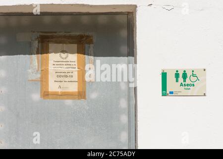 Panneau sur la porte des toilettes publiques dans le parc naturel des montagnes de Malaga, fermé en raison de la pandémie mondiale Covid-19. Espagne. Banque D'Images