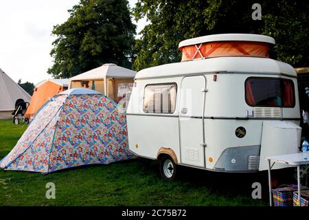 Terrain de camping avec tentes et caravane rétro dans un camping festival, Norfolk Banque D'Images