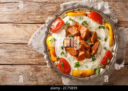 Ali Nazik kebab est de petites tranches d'agneau tendre dans une sauce au poivre rouge épais avec une purée d'aubergines parfumées dans l'assiette sur la table. T. Horizontale Banque D'Images