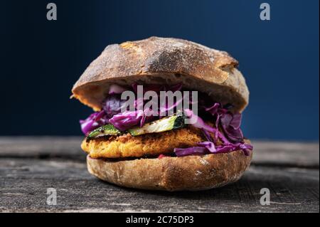 Délicieux hamburger végétarien fait maison avec courgettes grillées et chou rouge dans un pain au levain. Banque D'Images