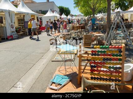 L'ISLE-SUR-LA-SORGUE, FRANCE - 15 AOÛT 2018 : photo donnant un aperçu du marché antique avec un Abacus et une trompette en premier plan et des gens Banque D'Images