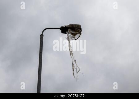 Les suites d'un feu de joie de la onzième nuit montrant une lumière de rue fondue à côté du Dr Pitt Memorial Park, sur la route inférieure Newtownards Road à Belfast. Banque D'Images