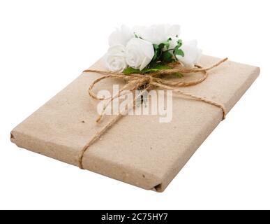 Cadeau emballé dans du papier artisanal avec ruban et décoration florale. Banque D'Images