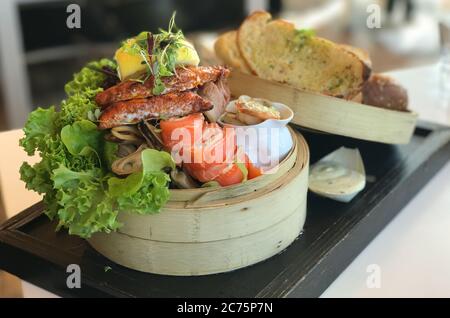 Délicieux plateau de fruits de mer avec filet de poisson frit, moule marinée au vinaigre, saumon fumé, fromage à la crème et pain grillé à l'ail. Banque D'Images